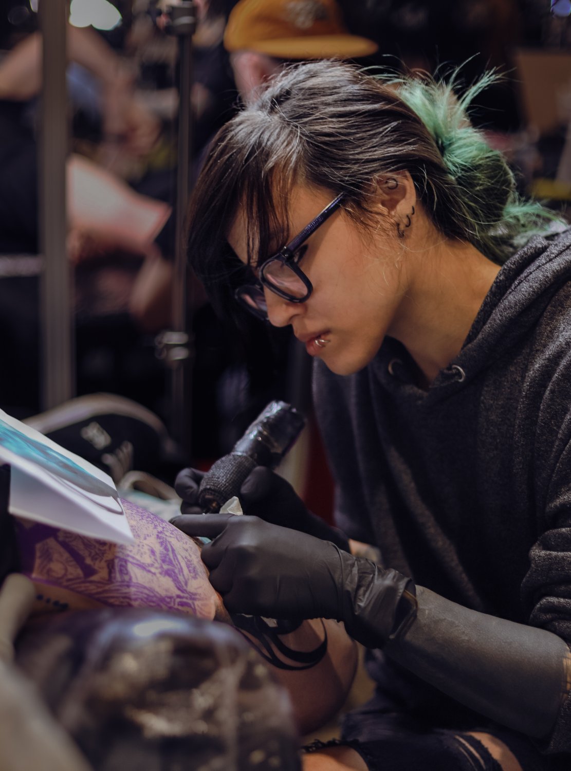 Kimmi Gayle tattooing a client at a convention